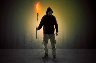 Boş bir alanda flambeau yanma ile yürüyen adam