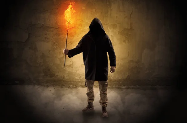 Wanderer mit brennender Fackel vor bröckelnder Mauer — Stockfoto