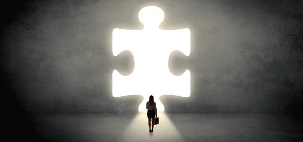 Donna in piedi di fronte a un grande pezzo di puzzle — Foto Stock