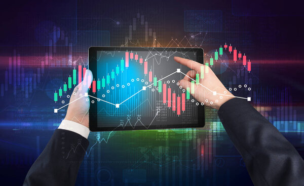 Hand holding tablet with global reports and stock market change concept