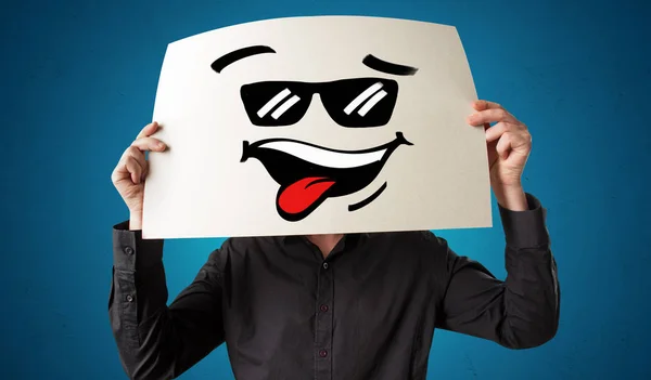 Persona sosteniendo un papel con cara de emoticono fresco —  Fotos de Stock