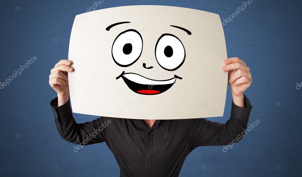 Student holding a paper with laughing emoticon in front of his face