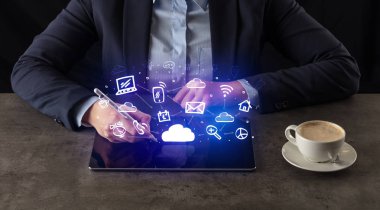 Yukarıdaki uygulama simgeleriyle tablet üzerinde çalışan iş kadın