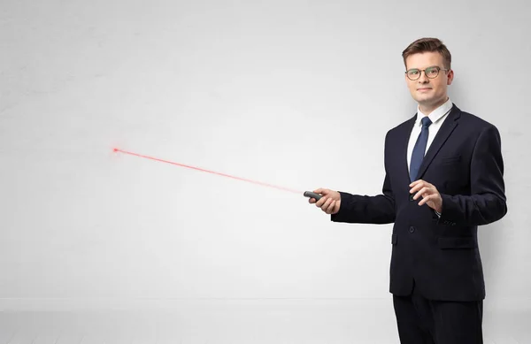 Biznesmen z laserowym wskaźnikiem i tło białe ściany — Zdjęcie stockowe