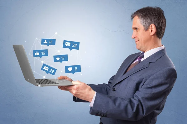 Mann hält Laptop mit Social-Media-Meldungen — Stockfoto