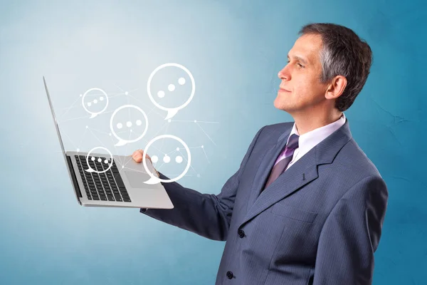 Man holding laptop with speech bubbles — Stock Photo, Image