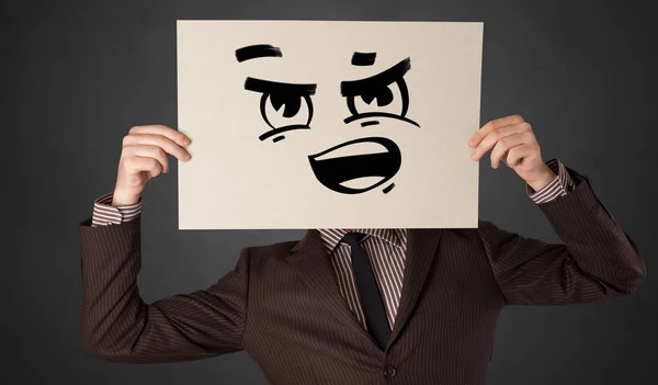Person hält ein Papier mit lustigen Emoticons vor ihr Gesicht — Stockfoto