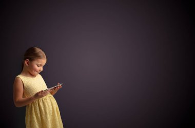 Tablet ile koyu arka plan kullanarak sevimli küçük kız