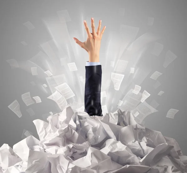 Hand coming out from paper pile — Stock Photo, Image