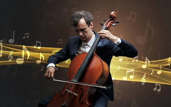 Musicien jouant sur violoncelle avec des notes autour — Photo