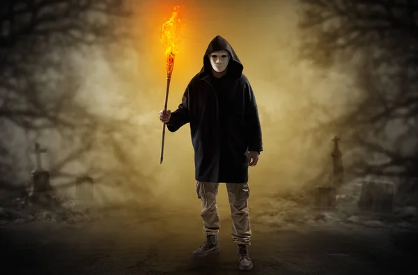 Man coming out from a thicket with burning flambeau — Stock Photo, Image