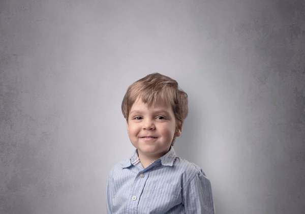 Menino adorável na frente de uma parede vazia — Fotografia de Stock