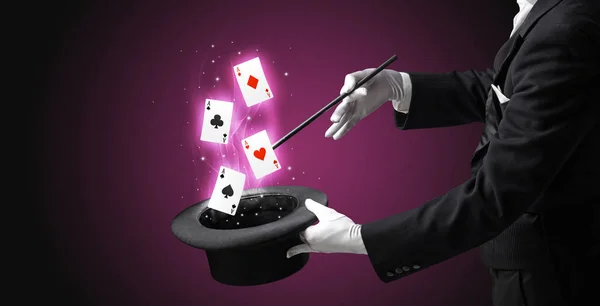 Magician making trick with wand and playing cards — Stock Photo, Image