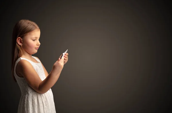 Cute little girl using tablet with dark background Stock Photo