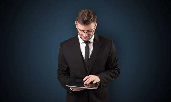 Geschäftsmann hält Tablet mit dunklem Hintergrund — Stockfoto
