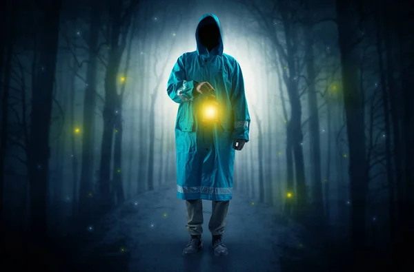 Mysterious man coming from a path in the forest with glowing lantern concept — Stock Photo, Image