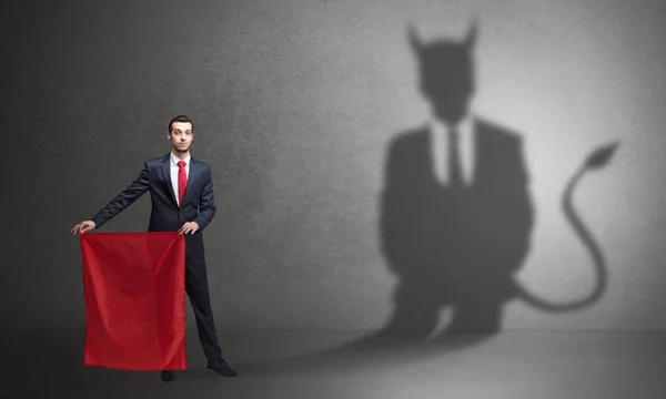Бизнесмен с дьявольской тенью и тореадором — стоковое фото