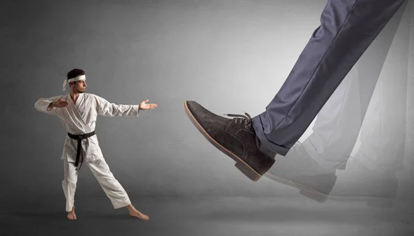 Großer Fuß tritt kleinen Karate-Mann — Stockfoto