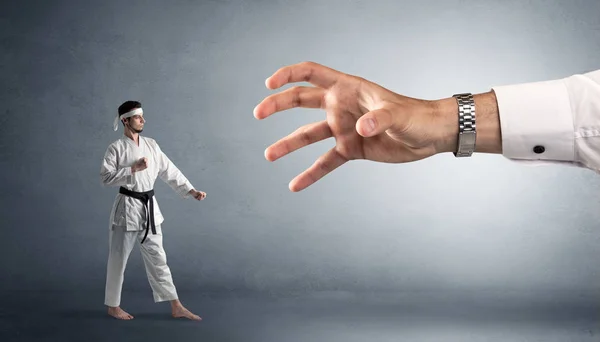 Stor hand fånga små karate man — Stockfoto