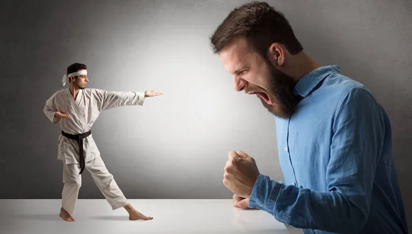 Riesenmann brüllt einen kleinen Karate-Mann an — Stockfoto