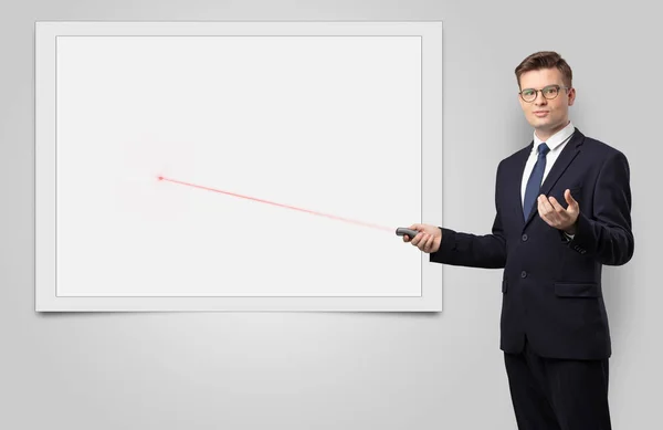 Businessman with laser pointer and copyspace white blackboard — Stock Photo, Image