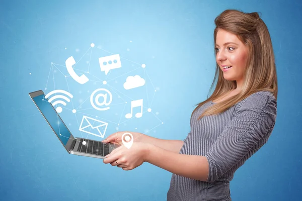 Woman holding laptop with online symbols — Stock Photo, Image