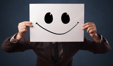 Yüzünün önünde komik ifade ile bir kağıt tutan kişi