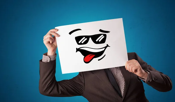 Persona sosteniendo un papel con cara de emoticono fresco —  Fotos de Stock