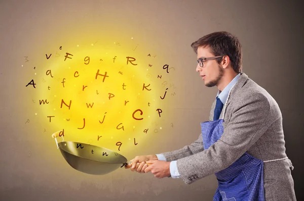 Person cooking letters in wok — Stock Photo, Image