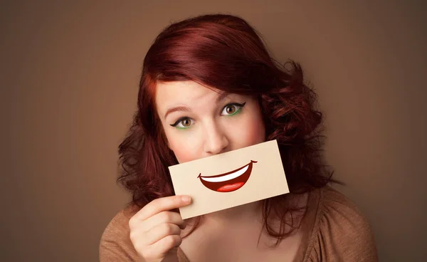 Pessoa segurando cartão na frente de sua boca — Fotografia de Stock