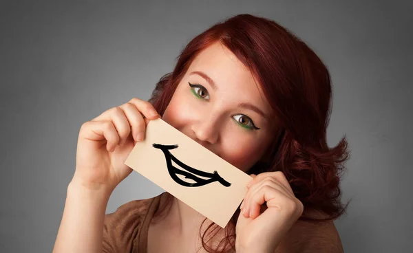 Человек, держащий перед ее ртом открытку — стоковое фото