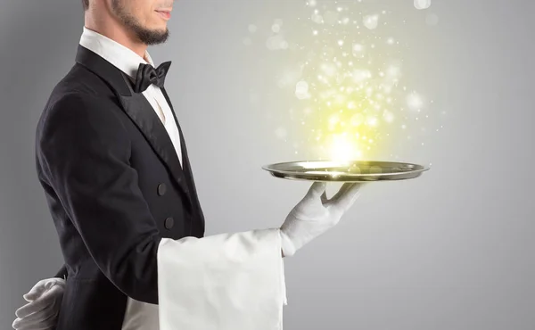 Waiter serving mysterious light on tray — Stock Photo, Image