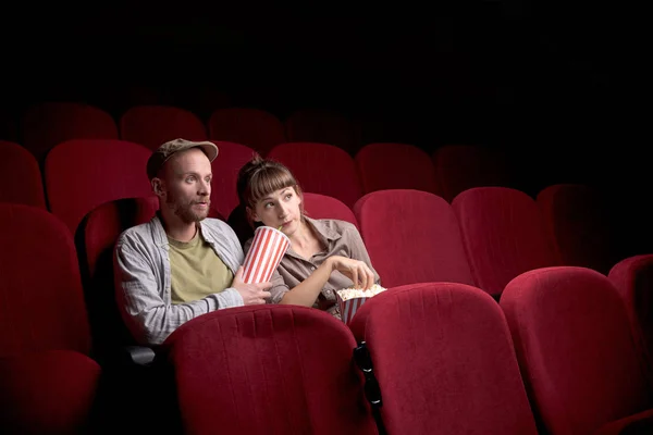 Jovem casal sentado no cinema vermelho — Fotografia de Stock