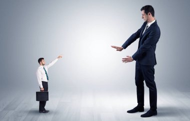 Dev bir işadamı için işaret eden küçük iş adamı