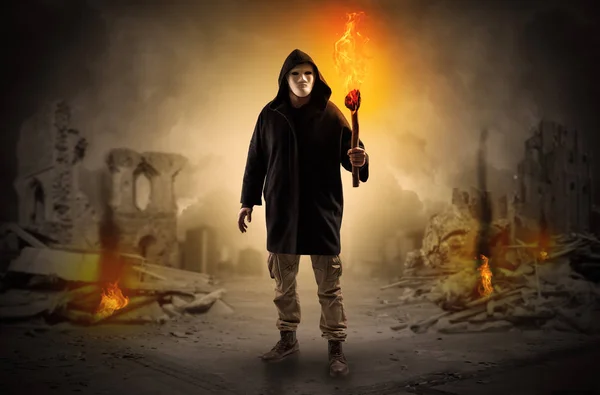 Man coming with burning flambeau at a catastrophe scene concept — Stock Photo, Image