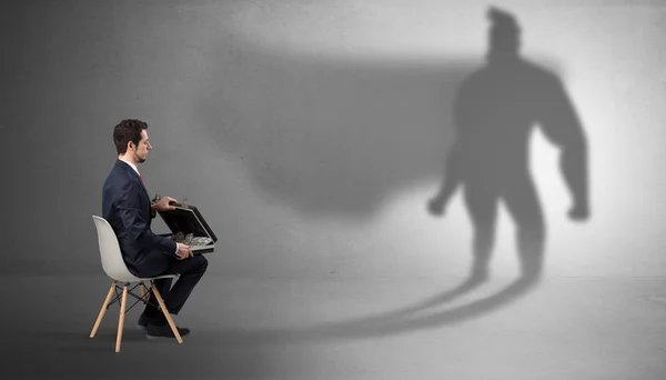 Бізнесмен залишається і пропонує речі в супергеройську тінь — стокове фото