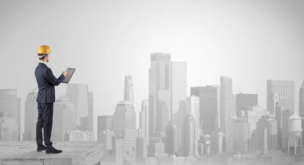 Architect standing on top of a maze and holding a plan — Stock Photo, Image