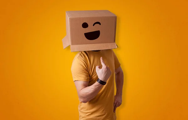 Homem engraçado sorrindo com cabeça de caixa de papelão — Fotografia de Stock