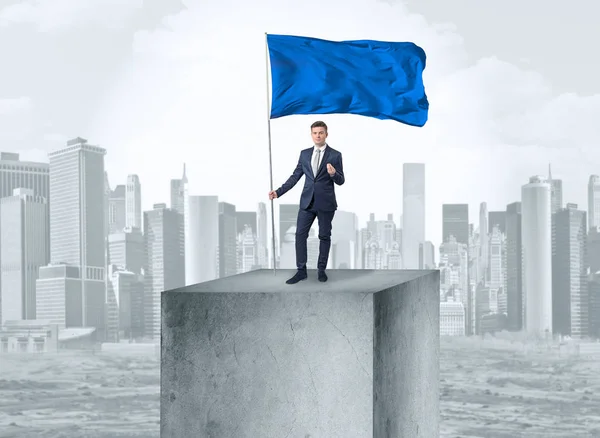 Businessman on the top of the city holding flag — Stock Photo, Image