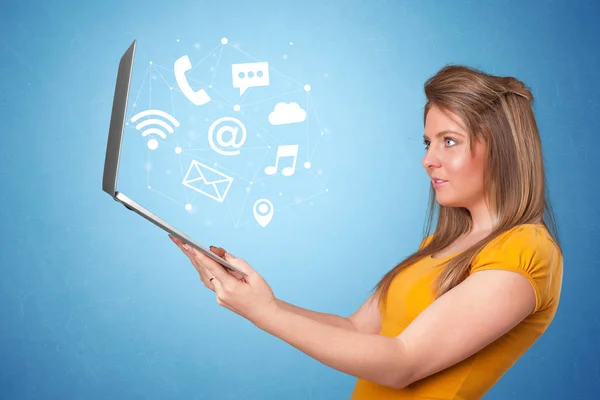 Woman holding laptop with online symbols — Stock Photo, Image