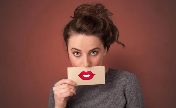 Une personne souriante avec une carte devant la bouche — Photo