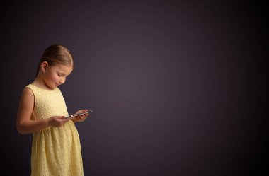 Tablet ile koyu arka plan kullanarak sevimli küçük kız