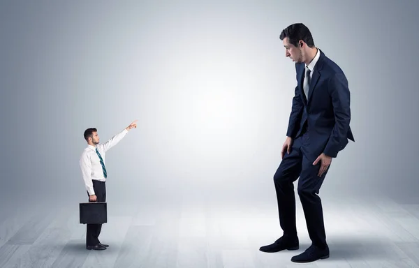 Pequeno empresário apontando para um empresário gigante — Fotografia de Stock