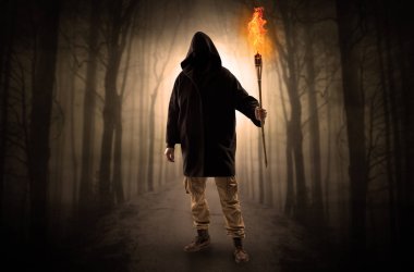 Adam flambeau onun el kavramında yanma ile karanlık ormandan gelen geliyor
