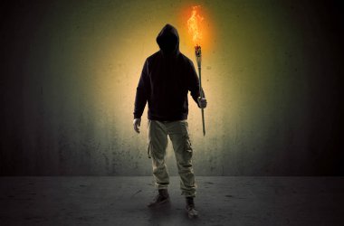 Boş bir alanda flambeau yanma ile yürüyen adam