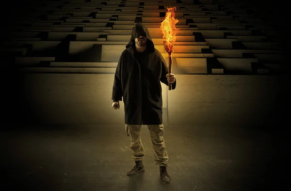 Człowiek, pochodzących ze spalania flambeau od koncepcji labirynt — Zdjęcie stockowe