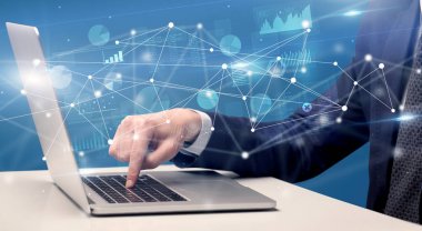 El laptop ile bağlantılı bir rapor ve grafikler çevresinde yazarak