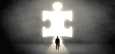 Bir büyük bulmaca parçası önünde duran işadamı