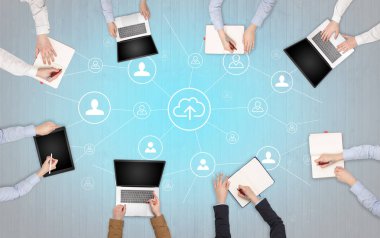 Dizüstü bilgisayarlar ve office konseptiyle tablet üzerinde çalışan bir grup ile aygıt içinde insan eller