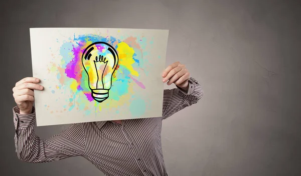 Persona sosteniendo un papel con concepto de bulbo colorido — Foto de Stock